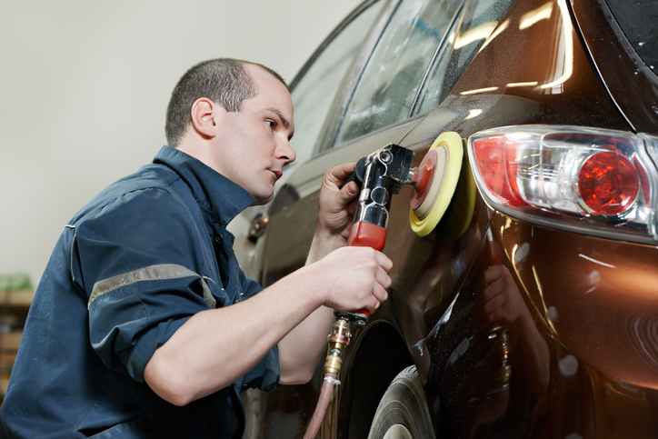 Technicien en esthétique automobile utilise une polisseuse