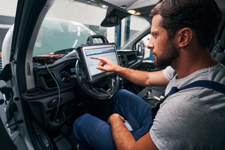 Étudiant en programme de mécanique automobile qui travaille avec un outil de diagnostic automobile