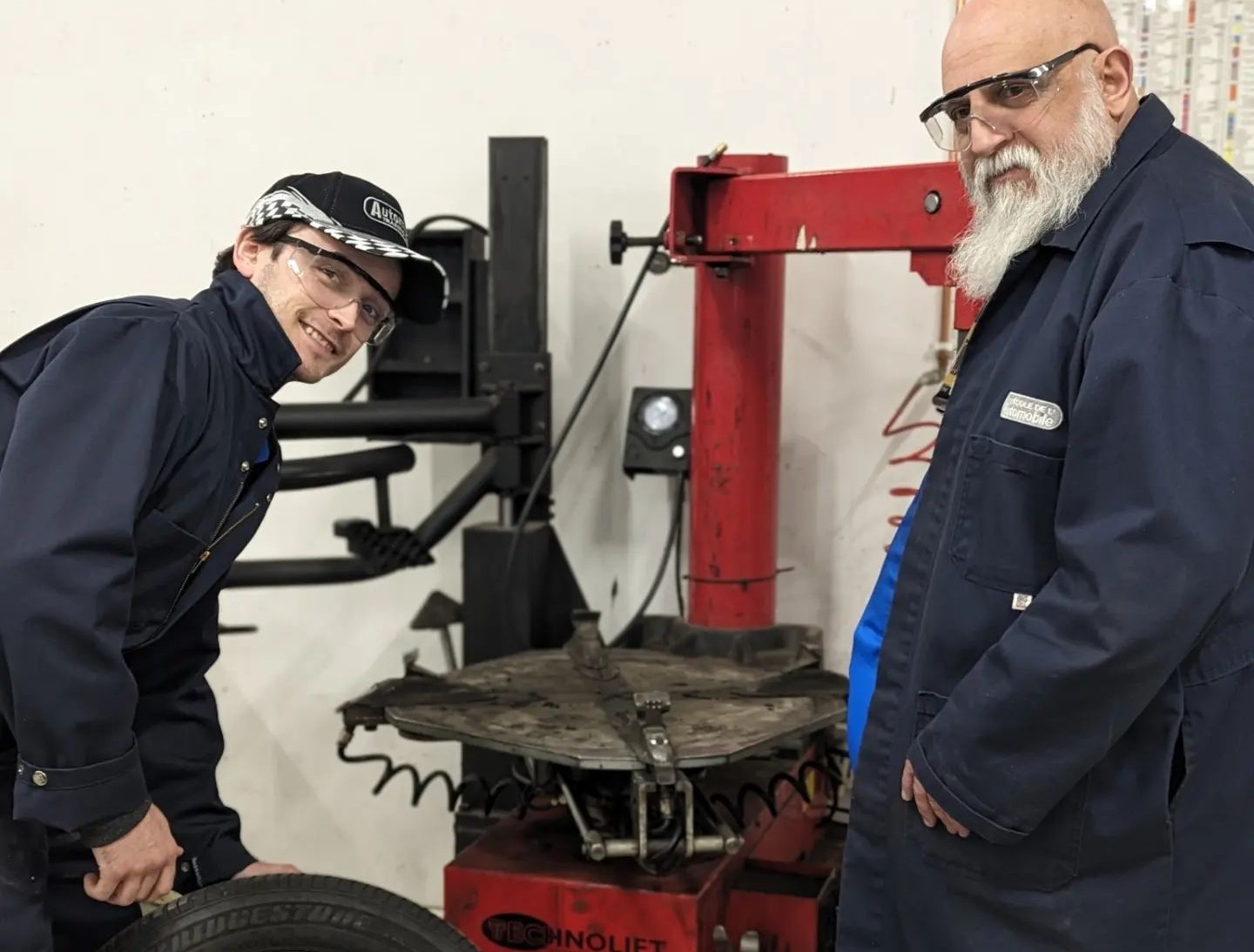 Photo instructeur travaillant sur des véhicules dans un atelier moderne, reflétant les exigences de l’industrie automobile.