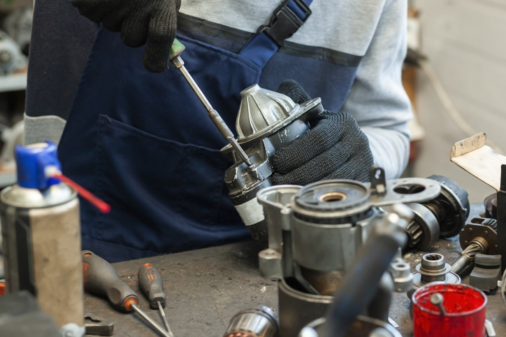 Technicien expérimenté guidant un collègue en reconversion dans l’industrie auto
