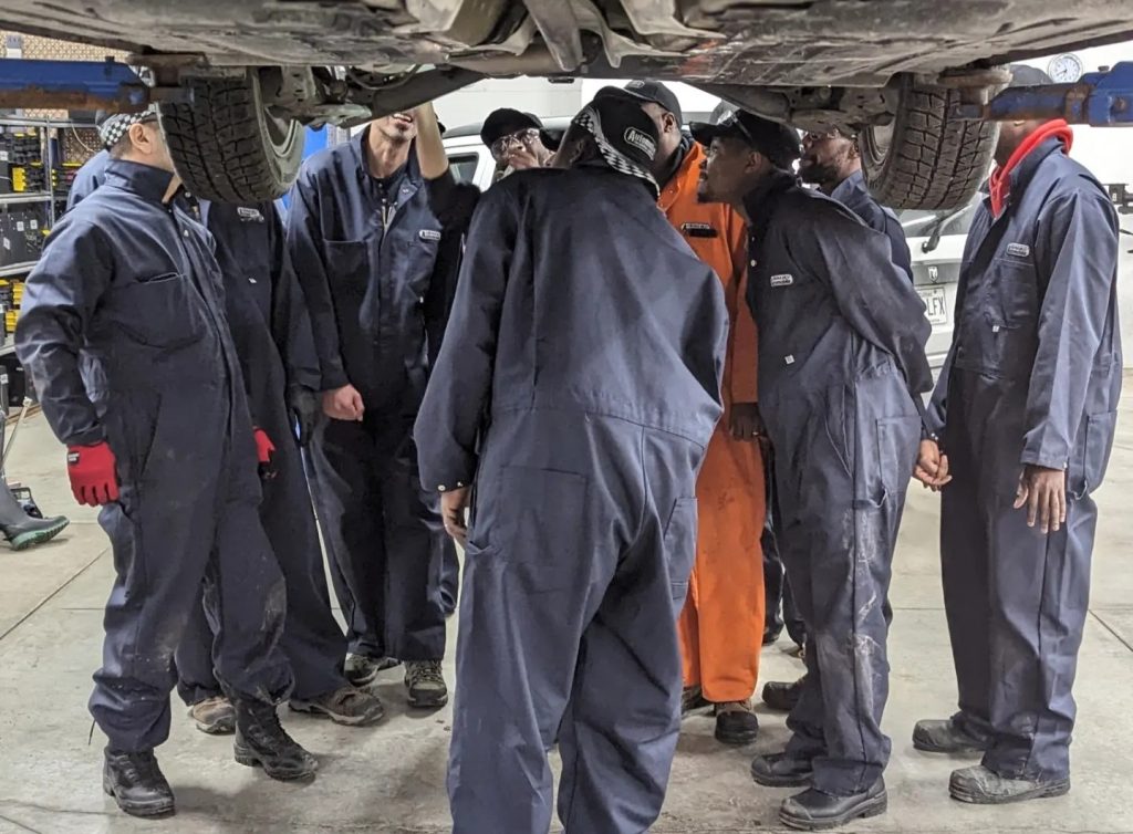 Étudiants en train de réparer un moteur dans le cadre d’un DEP en mécanique automobile.