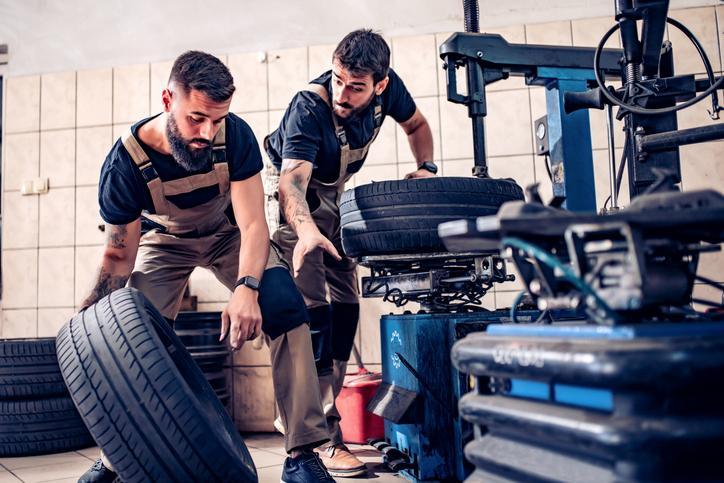 Vue rapprochée d’un formateur expliquant un composant moteur à un étudiant pendant un cours de DEP en Mécanique automobile