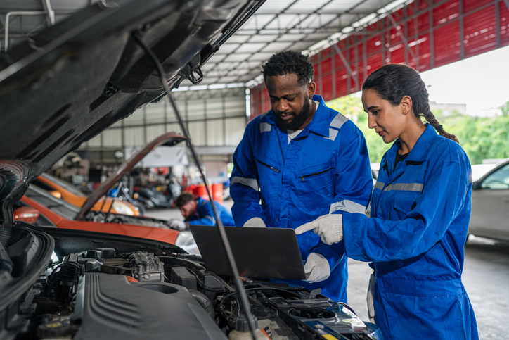 Étudiants passionnés apprenant à travailler avec des voitures dans un environnement professionnel