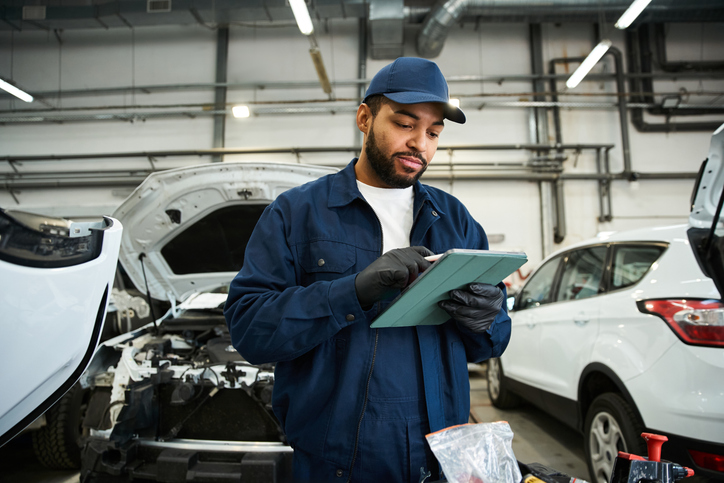 Étudiant en atelier pratiquant une formation en mécanique automobile pour apprendre à travailler sur des autos