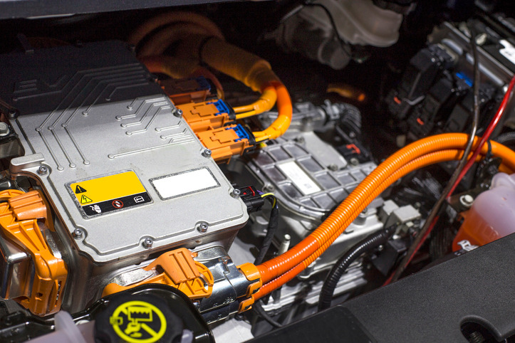 Atelier automobile où un technicien véhicule électrique utilise des outils isolés