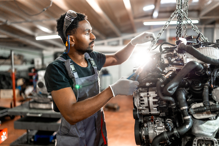 Nouvel arrivant suivant une formation en mécanique automobile dans un atelier