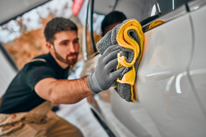 technicien en esthétique automobile nettoyant l’intérieur d’un véhicule