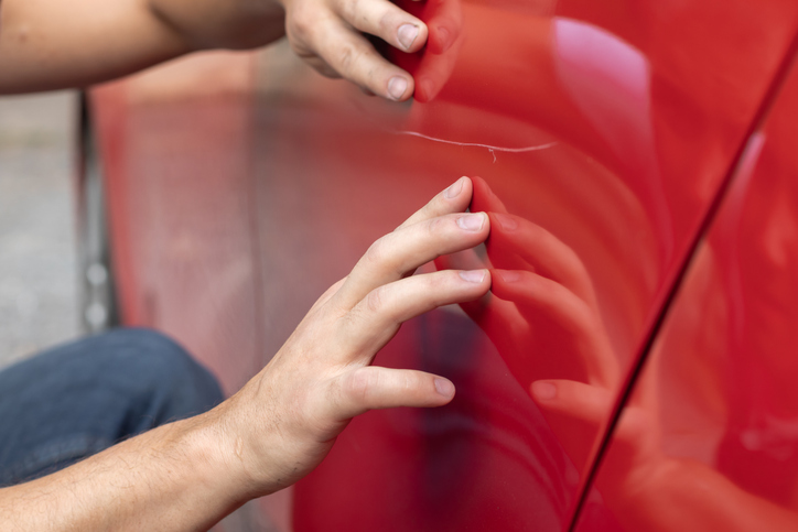 égratignure profonde sur le capot d’une voiture noire