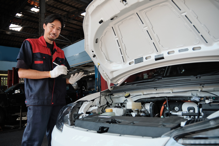 technicien effectuant un diagnostic auto hybride en atelier