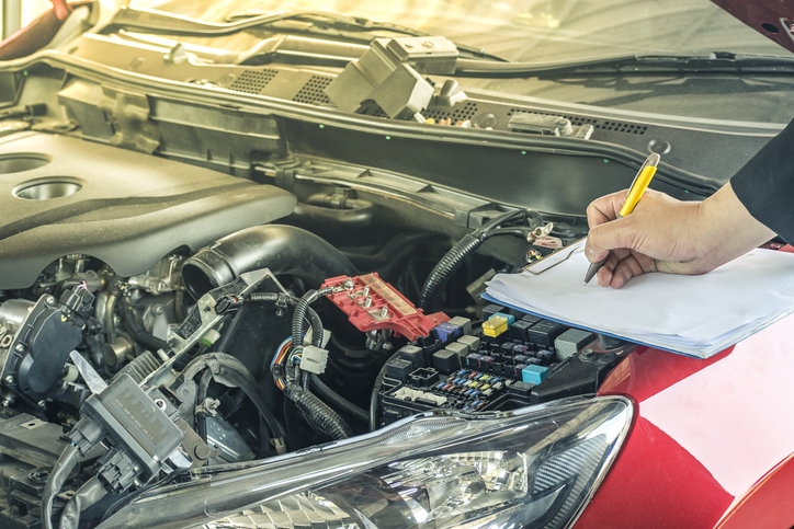 technicien automobile effectuant un diagnostic visuel en atelier