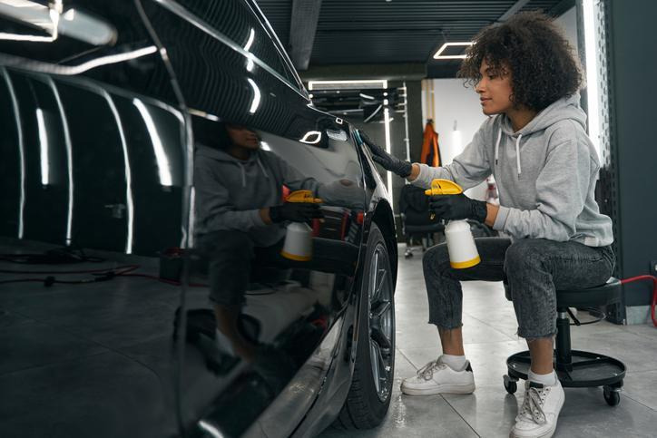futur technicienne en esthétique automobile effectuant le polissage d’une carrosserie