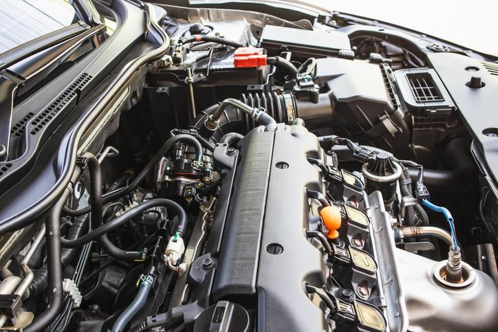 commis comparant une pièce automobile OEM et une pièce de marché secondaire au comptoir